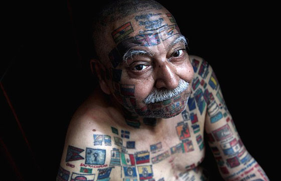 مهووس غينيس.. نقش 366 علما على جسده وخلع اسنانه للماصات والشموع صورة رقم 10