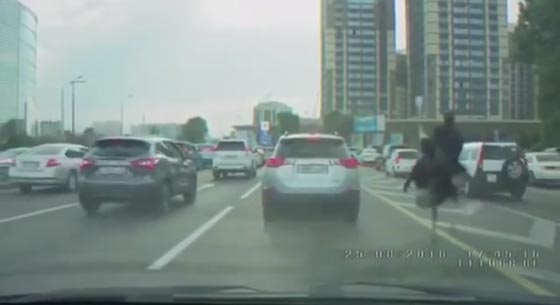 شاهدوا رجلًا يرتدي زيًّا أسود ويمتطي ظهر نعامة في شوارع  صورة رقم 4