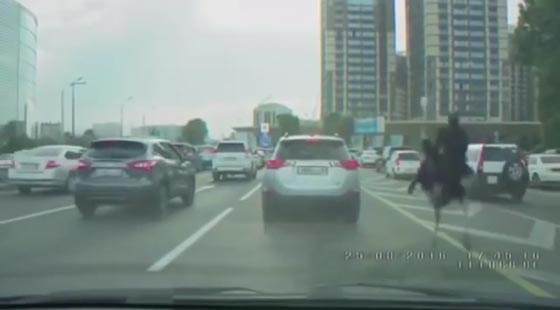 شاهدوا رجلًا يرتدي زيًّا أسود ويمتطي ظهر نعامة في شوارع  صورة رقم 5