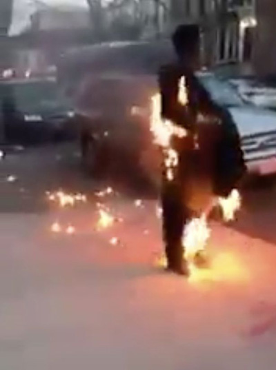 لقطة غريبة.. رجل يسير في الشارع بكل هدوء والنار تشتعل فيه  صورة رقم 1