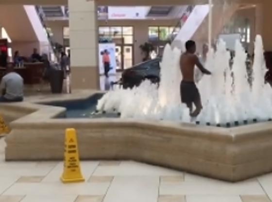 شاب يسبح ويرتع في نافورة داخل مركز تجاري يثير دهشة المتسوقين صورة رقم 1