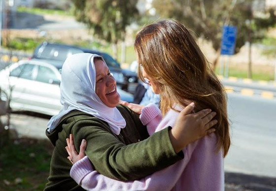 صور الملكة رانيا جالسة على الارض بجوار فرن الخبيز لتشجيع المتطوعات صورة رقم 3