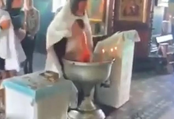 أم تنقضّ على قس روسي وهو يغرق طفلها بعنف في الماء أثناء تعميده! فيديو صورة رقم 3 أم تنقضّ على قس روسي وهو يغرق طفلها بعنف في الماء أثناء تعميده! فيديو صورة رقم 3
