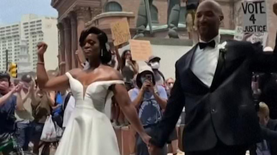 عروسان يحتفلان بزفافهما في مسيرة احتجاجية صورة رقم 2