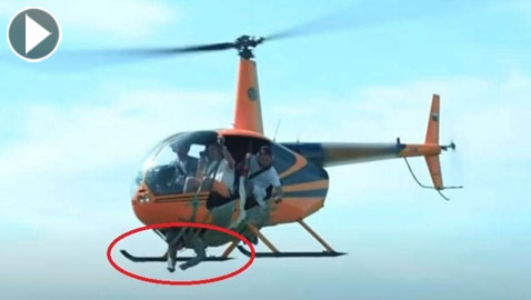 فيديو لتجربة مرعبة للغاية.. ألصق شخص بجسم مروحية وطار به