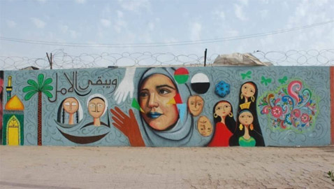 صور: شباب عراقيون يرسمون على حوائط شوارع بغداد لاعادة  البهجة والبسمة للعاصمة واهلها