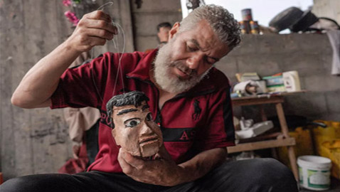 بالصور: صانع دمى من فلسطين المحروقة يصنعها من علب المعلبات