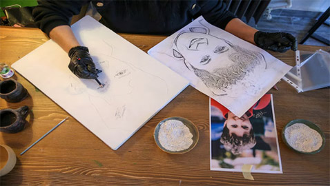 صور: فنانة تركية ترسم لوحتين لامرأة برماد جثتها